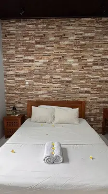 a bedroom with a white bed with towels on it at MOOvilla 1 Seminyak, Bali in Umalas