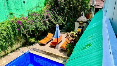 an overhead view of a patio with chairs and an umbrella at Ellenbrook Rooms 18 by Mulia Cottage in Seminyak
