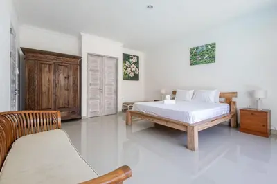 a bedroom with a bed and a bench in it at Villa Chunga-changa Double six in Seminyak