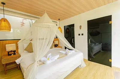 a bedroom with a white bed with white flowers on it at Mya Harmony Villas Seminyak in Seminyak