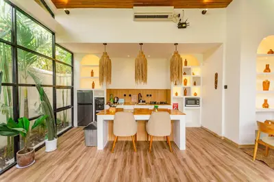 a kitchen with a large island with two chairs at Mya Harmony Villas Seminyak in Seminyak