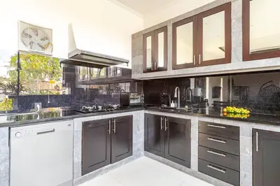 a kitchen with black and white cabinets and a sink at Villa with private pool in Nusa Dua in Nusa Dua