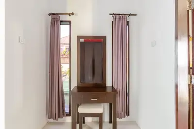 a dresser with a mirror and a chair next to a window at Villa with private pool in Nusa Dua in Nusa Dua