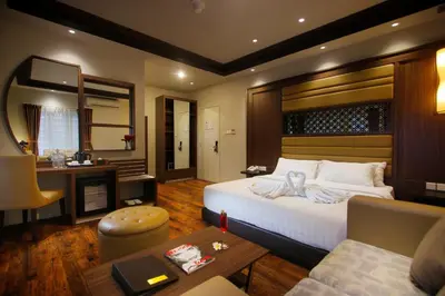 a bedroom with a large bed and a living room at The Lerina Hotel Nusa Dua in Nusa Dua