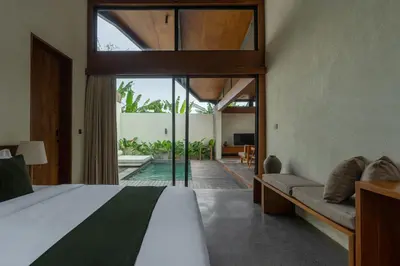a bedroom with a bed and a view of a pool at Rarama Teba Villa in Umalas