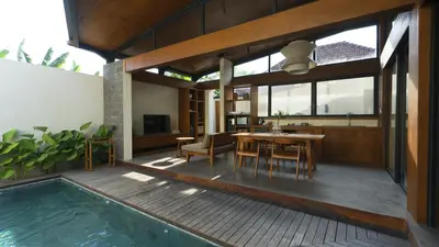 a house with a swimming pool and a table and chairs at Rarama Teba Villa in Umalas