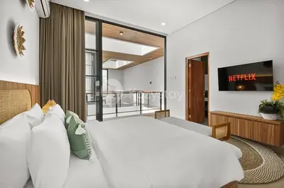 a bedroom with a white bed and a balcony at Kanani Villa by Kozystay - Umalas in Seminyak