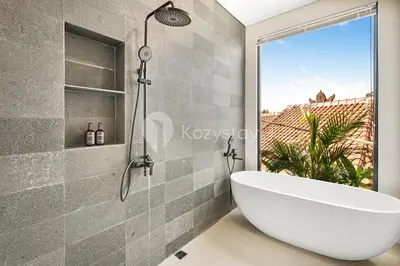 a bathroom with a white tub and a window at Kanani Villa by Kozystay - Umalas in Seminyak