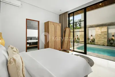 a bedroom with a bed and a swimming pool at Verde Villa by Kozystay - Umalas in Kerobokan