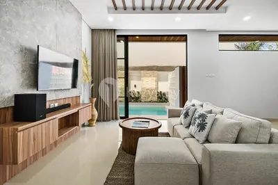 a living room with a couch and a tv at Verde Villa by Kozystay - Umalas in Kerobokan