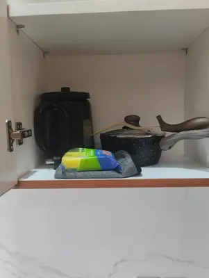 a kitchen shelf with a kitchen utensils on it at Shin In Bali in Kuta