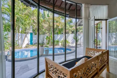 a bedroom with a large window and a swimming pool at Peaceful 2bd Seminyak villa with Private Pool and Garden in Seminyak