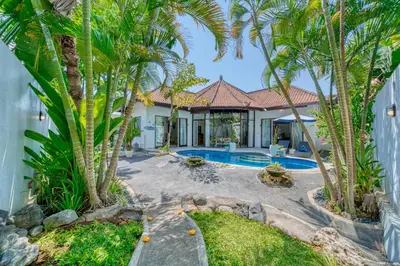 a villa with a swimming pool and palm trees at Peaceful 2bd Seminyak villa with Private Pool and Garden in Seminyak