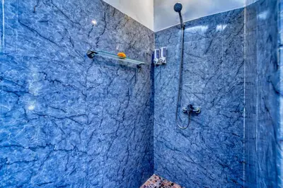 a bathroom with a shower with a blue marble wall at Peaceful 2bd Seminyak villa with Private Pool and Garden in Seminyak
