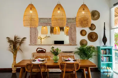 a dining room with a table and chairs and a mirror at Villa Bardo by Pertama Management in Seminyak