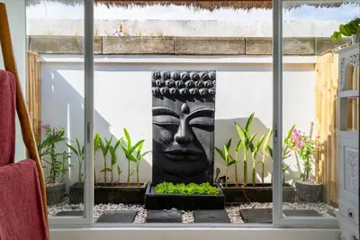a statue in front of a window with plants at Villa Bardo by Pertama Management in Seminyak