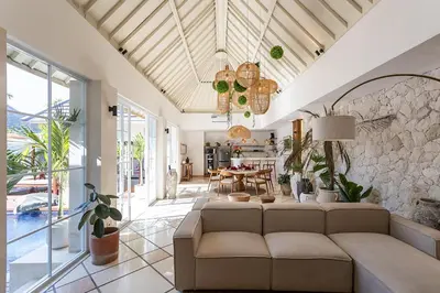 a living room with a couch and a stone wall at Villa Dalon by Optimum Bali Villas in Seminyak