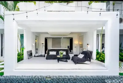 a white patio with black chairs and a table at Villa bella vista in Seminyak