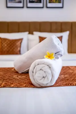 a towel with a flower on top of a bed at Promo!! New Rosa Villa Muding, Luxury and cozy 3Bedrooms Villa in Heart of Kerobokan with Special Office Room in Kerobokan