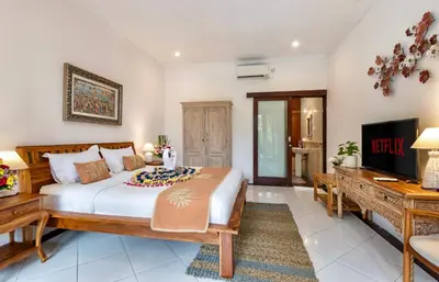 a bedroom with a bed and a desk and a television at Bens Tunjung Villa Two-Bedroom with Private Pool Kuta in Seminyak