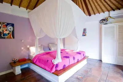 a bedroom with a pink bed with a canopy at Villa Kija in Seminyak