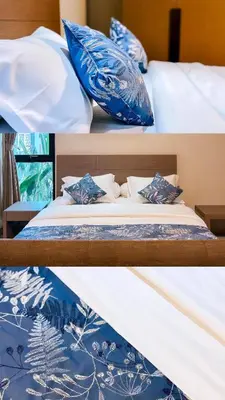two beds with blue and white pillows on them at Nawasena Suites in Sanur