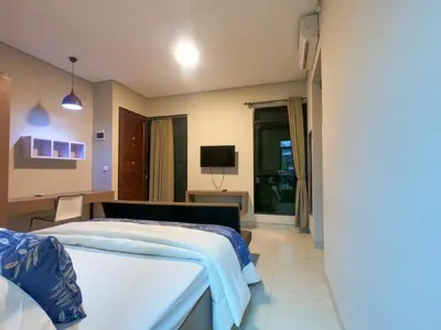 a bedroom with a bed and a television in it at Nawasena Suites in Sanur