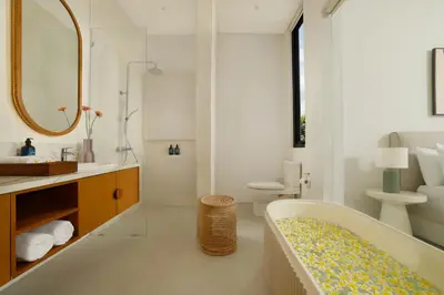 a bathroom with a tub and a sink and a toilet at Villa Kalem Canggu by Nakula in Canggu