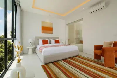 a bedroom with a bed and a bath room at Villa Kalem Canggu by Nakula in Canggu