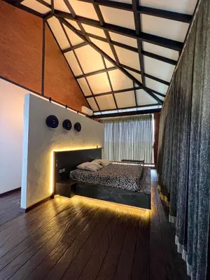 a bedroom with a bed and a wooden floor at The Edge by Anima in Kerobokan