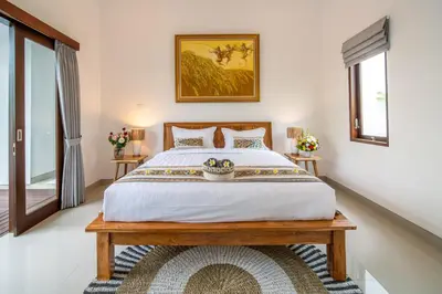 a bedroom with a large bed and two windows at Arts Biyu Villa Two-Bedroom with Private Pool Kuta in Seminyak