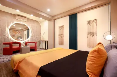 a bedroom with a large bed and a red chair at CANGGU BRAND NEW 6Bed VILLA! BEST LOCATION! A STEP-FREE Design Highlight for Families & Friends in Canggu