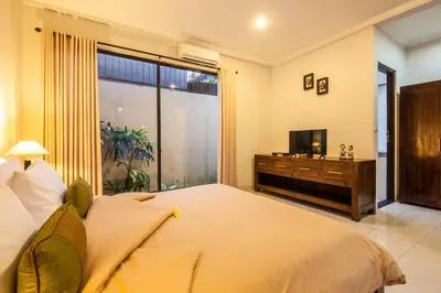 a bedroom with a large bed and a television at 4-BR Private Pool Legian Villa, 5-min walk to beach and shops in Seminyak