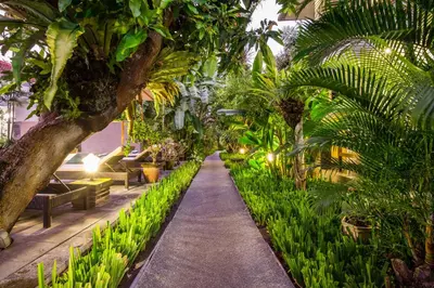 a garden with palm trees and a walkway at 10-BR Private Pool Legian Villa 5-Min Walk to Beach and Shops in Seminyak