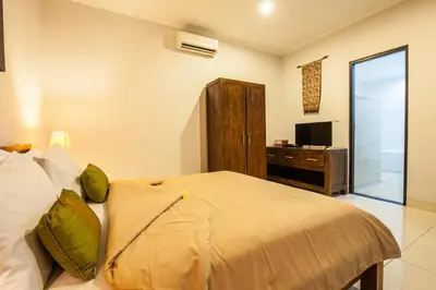 a bedroom with a bed and a desk and a television at 10-BR Private Pool Legian Villa 5-Min Walk to Beach and Shops in Seminyak
