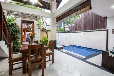 a patio with a table and chairs and a swimming pool at 10-BR Private Pool Legian Villa 5-Min Walk to Beach and Shops in Seminyak