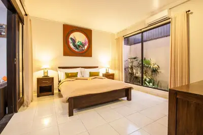 a bedroom with a bed and a large window at 7-BR Private Pool Legian Villa 5-Min Walk to Beach and Shops Bali in Seminyak