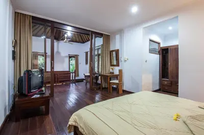 a bedroom with a bed and a tv in it at 6-BR Garden Legian Villa 5-Min Walk to Beach and Shops Bali in Seminyak