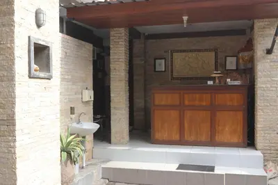 a wooden door in a brick building with a sink at Ronta Bungalows in Legian