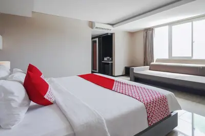 a bedroom with a large bed with red pillows at Townhouse Oak Denpasar at Mahendradatta in Denpasar