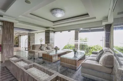 a living room with couches and tables and windows at Townhouse Oak Denpasar at Mahendradatta in Denpasar