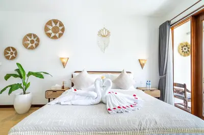 a bedroom with two swans towels on a bed at Villa Gea by JB Villas in Seminyak