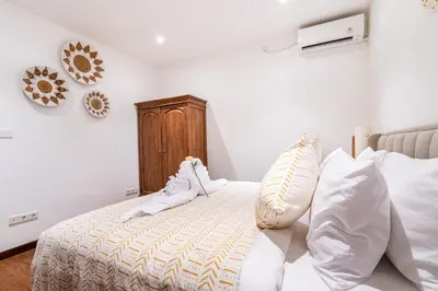 a bedroom with a bed with white sheets and pillows at Villa Gea by JB Villas in Seminyak