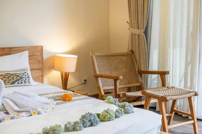 a bedroom with two beds and a chair at Arts Cherry Villa Satu Two-Bedroom with Private Pool Kuta in Kerobokan