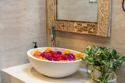 a white bowl filled with colorful flowers on top of a sink at Arts Cherry Villa Dua Two-Bedroom with Private Pool Kuta in Kerobokan