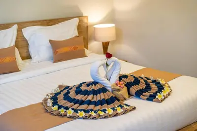 a hotel room with a bed with a dress on it at Arts Cherry Villa Dua Two-Bedroom with Private Pool Kuta in Kerobokan
