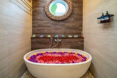 a bath tub filled with flowers in a bathroom at Arts Cherry Villa Dua Two-Bedroom with Private Pool Kuta in Kerobokan