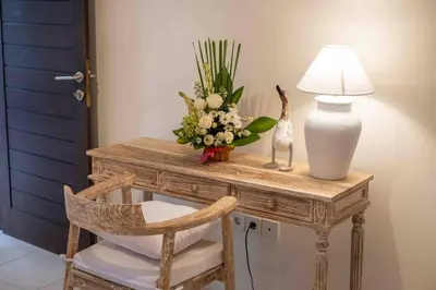 a table with a lamp and a vase of flowers on it at Bens Bidadari Villa Two-Bedroom with Private Pool Kuta in Seminyak