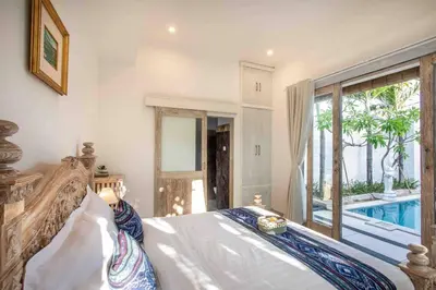 a bedroom with a bed and a swimming pool at Bens Kenanga Villa Three-Bedroom with Private Pool Kuta in Kerobokan