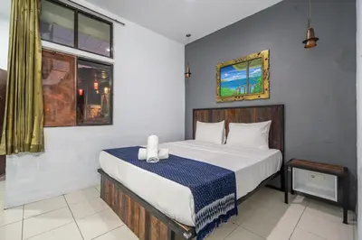 a bedroom with a bed and a window at Senyum Bali Inn 1BR Sanur in Sanur
